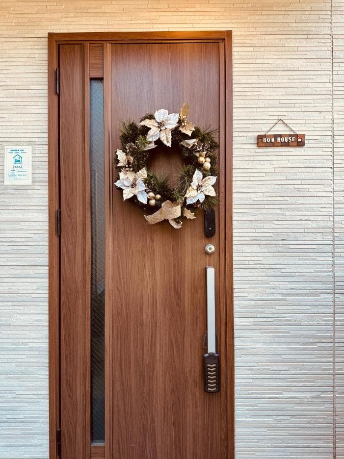 Traditional wooden entrance door with wreath at Bon House Kanamachi