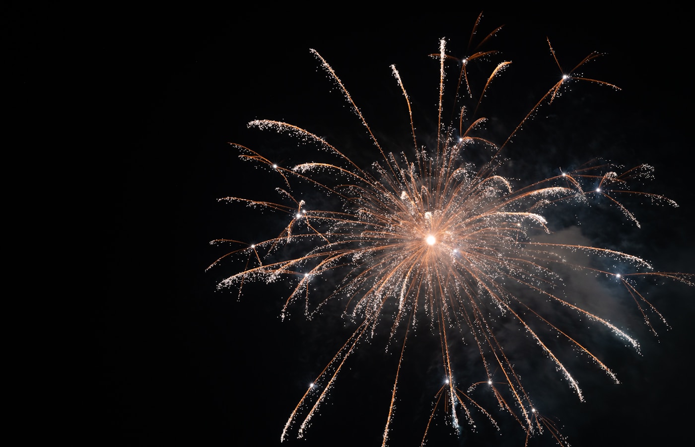 Low-angle view of fireworks over a Japanese river at night