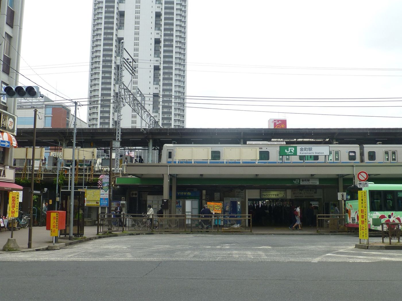 隔着公交总站看到的 JR 金町站北口,上方是「金町駅 Kanamachi Station」的站牌